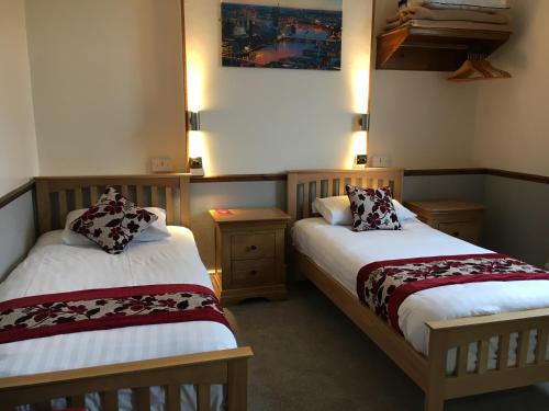 Dwa łóżka w pokoju z w obiekcie Lion and Fiddle w mieście Trowbridge