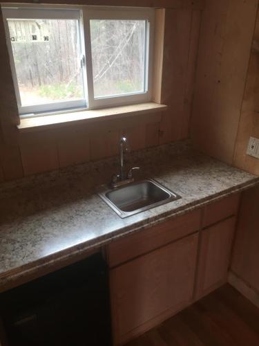a kitchen counter with a sink and a window at Cozy Cabin in the Catskills in East Durham