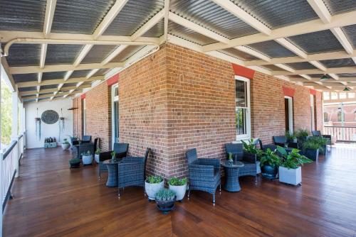 a room with a brick wall and chairs and plants at The Parkview Hotel Mudgee in Mudgee