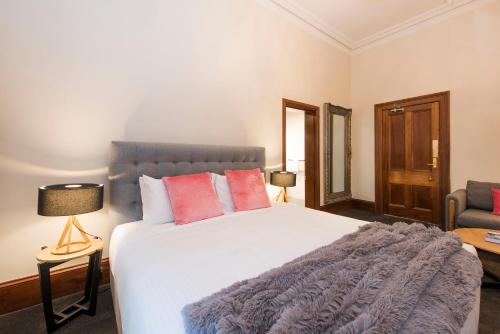 a bedroom with a large white bed with red pillows at The Parkview Hotel Mudgee in Mudgee