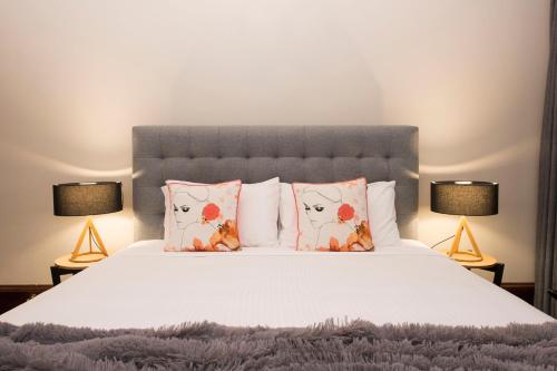 a bedroom with a bed with pillows and two lamps at The Parkview Hotel Mudgee in Mudgee