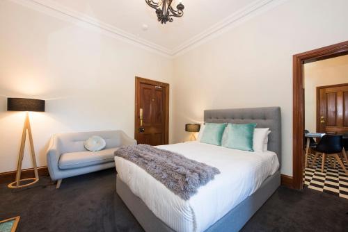 a bedroom with a bed and a chair in it at The Parkview Hotel Mudgee in Mudgee