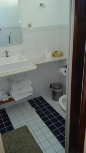 a white bathroom with a sink and a toilet at Pousada Alto da Pontinha in Araruama