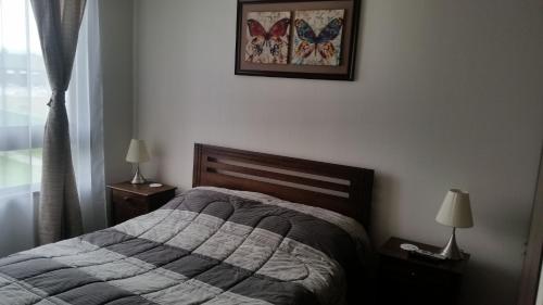1 dormitorio con 1 cama y una foto en la pared en Departamento en Pucon, en Pucón