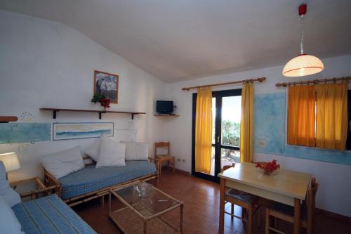 un soggiorno con un divano e un tavolo di Residence Baia Salinedda a San Teodoro
