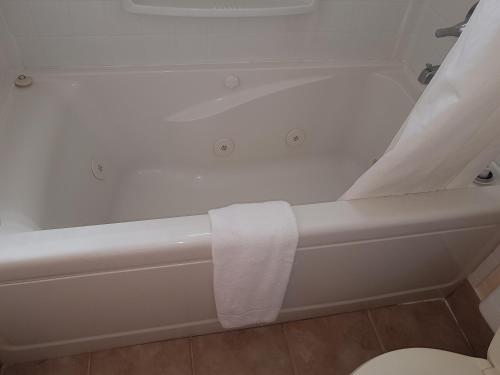 a bathtub with a towel on the side of it at Townhouse Motel in Longview