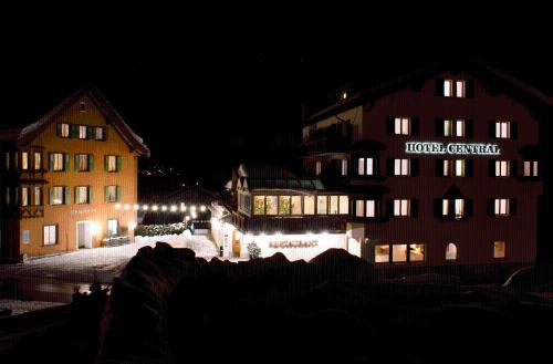a group of buildings at night with lights at Hotel Central in Obersaxen