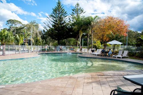una piscina en un parque con gente sentada en NRMA Batemans Bay Resort, en Batemans Bay