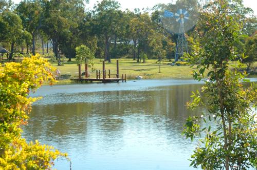 a pond with a playground and a waterwheel in a park at 1770 Southern Cross Travellers Retreat in Agnes Water