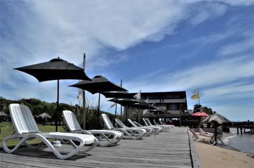 a row of white chairs and umbrellas on a dock at Bajos del Paraná in Tigre