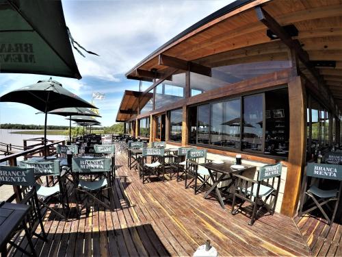a restaurant with tables and chairs on a wooden deck at Bajos del Paraná in Tigre