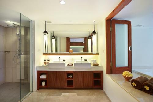 a bathroom with two sinks and a mirror at The Magani Hotel and Spa in Legian