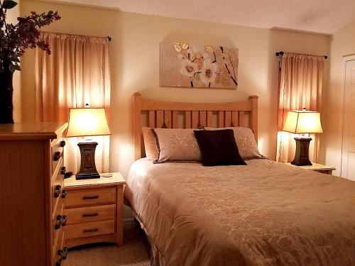 a bedroom with a large bed and two lamps at Key 2 Indian Creek Pool Home in Kissimmee