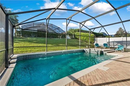a swimming pool in a house with a glass roof at Key 2 Indian Creek Pool Home in Kissimmee