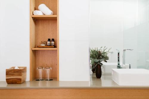 a bathroom counter with a sink and a vase of flowers at Royal Mail Hotel in Dunkeld