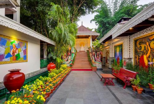 a building with a garden with flowers and a staircase at Mayfair Spa Resort & Casino in Gangtok