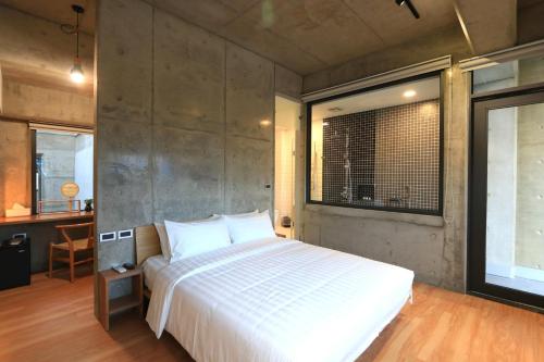a bedroom with a large white bed and a window at 墾丁 住在Zhuzai in Checheng