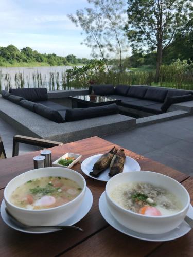 Ban Khlong Ta KhotPhotharam126 Resort的一张桌子,上面放着两碗汤和一些食物