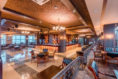 un ristorante con tavoli e sedie e un bar di Grand Hill Hotel Ulaanbaatar a Ulaanbaatar