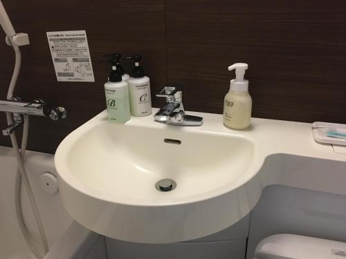 a bathroom with a white sink with bottles on it at KKR Hotel Nagoya in Nagoya
