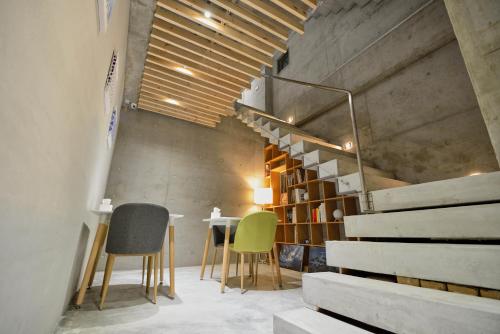 a room with two chairs and a table and a staircase at 墾丁 住在Zhuzai in Checheng
