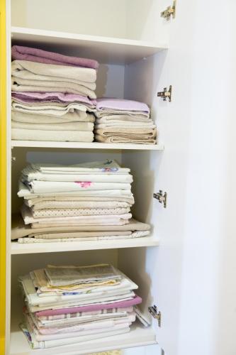 a closet filled with lots of folded clothes at Meidan Suites in Tbilisi City