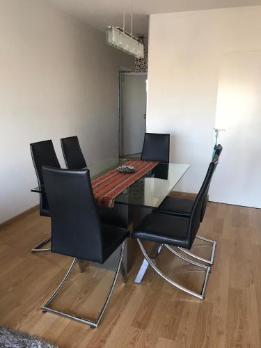 a dining room table with black chairs and a glass table at Amazing Apartament in Buenos Aires