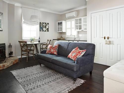 a living room with a couch and a kitchen at Bells at Killcare Boutique Hotel, Restaurant & Spa in Killcare