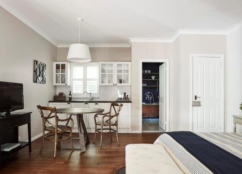a bedroom with a bed and a kitchen with a table at Bells at Killcare Boutique Hotel, Restaurant & Spa in Killcare