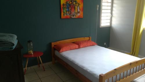 昂特爾德的住宿－La Villa Pitaya，一间卧室配有一张床和红色凳子
