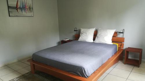 a bedroom with a bed and two night stands at La Villa Pitaya in LʼEntre-Deux