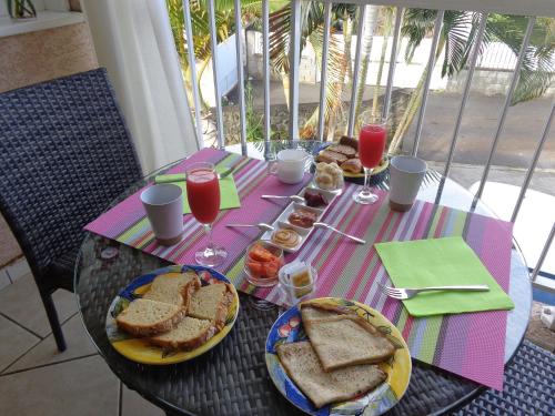 a table with sandwiches and drinks on top at La Villa Pitaya in LʼEntre-Deux