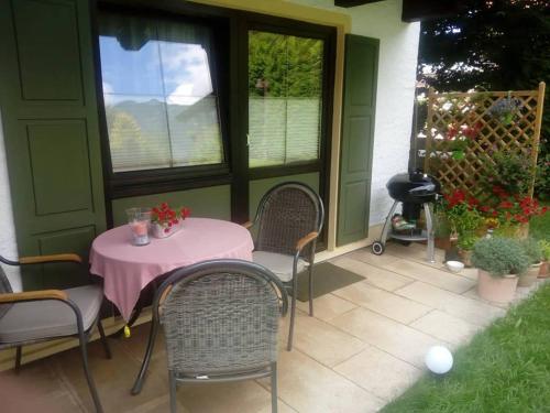 d'une terrasse avec une table, des chaises et une fenêtre. dans l'établissement Alpina Inzell 335 Chiemgaukarte, à Inzell