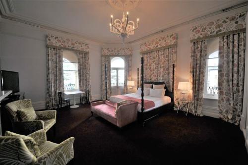 1 dormitorio con 1 cama, 1 silla y 1 lámpara de araña en Largs Pier Hotel, en Adelaida