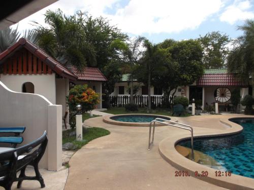 a swimming pool in front of a house at Ryans Resort in Prasat