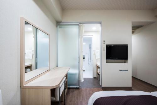 a bedroom with a large mirror and a tv at Nagasaki Bus Terminal Hotel in Nagasaki