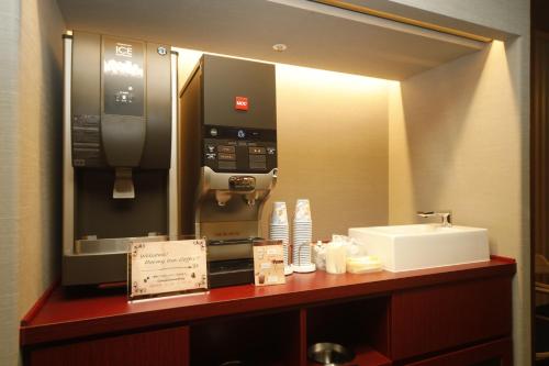 a bathroom with a pay phone and a sink at Dormy Inn Korakuen in Tokyo