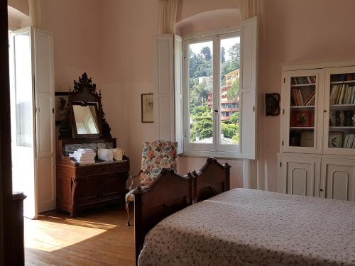 a bedroom with a bed and a window and a chair at Villa Olimpo in Rapallo