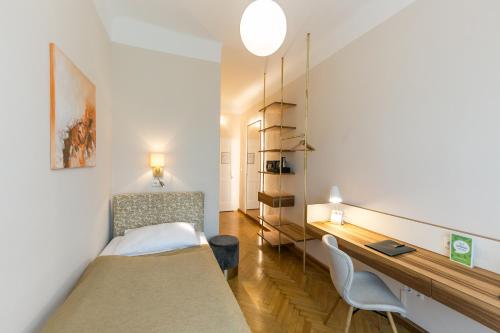 1 dormitorio con 1 cama, escritorio y sillas en Stadthotel zur goldenen Krone, en Weiz