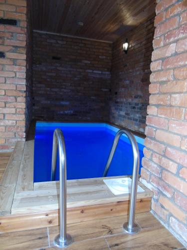 a hot tub in a brick wall with two metal rails at Poilsio namelis Plateliai in Plateliai