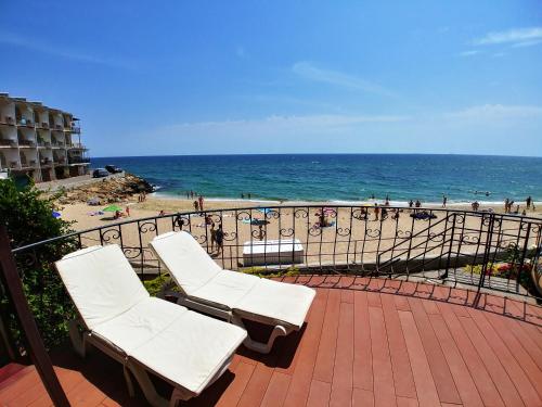 two white chairs sitting on a balcony overlooking the beach at Котеджі на приватному пляжу - Совіньйон 2025 in Odesa