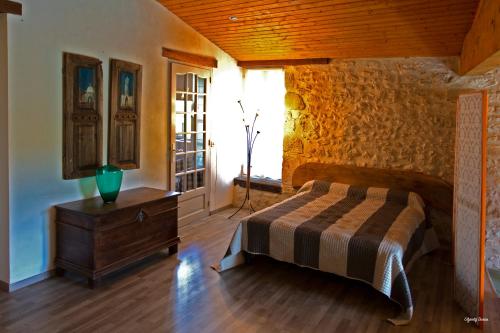 a bedroom with a bed and a wooden wall at Moulin de Cocussotte in Saint-Pierre-sur-Dropt