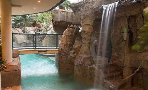 a waterfall in a building with a pool of water at Beachfront Mooloolaba Apartment- 7th Floor in the Landmark Resort in Mooloolaba