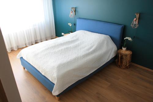 a bedroom with a bed with a blue headboard at Kesklinna Apartement in Haapsalu