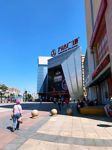a man walking in front of a shopping center at Metropolo Shenyang Wanda Plaza-Beiyi Road in Shenyang