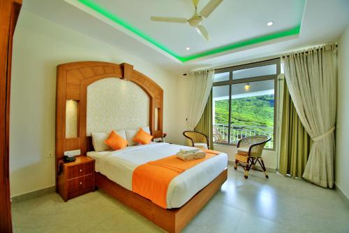 a bedroom with a large bed and a large window at Monsoon Grande in Munnar