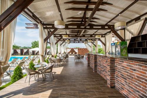 a patio with tables and chairs and a brick wall at Giowine Hotel & Restaurant in Cricova
