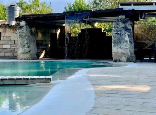 a swimming pool with a water fountain at Le Pentume in Arnesano