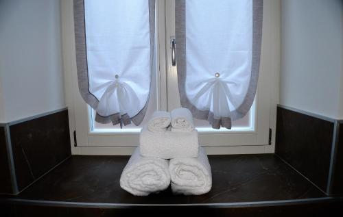 a pair of towels sitting in front of two windows at Aquila in Arco