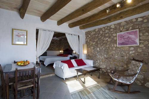 a bedroom with two beds and a stone wall at Agroturismo Sa Vall in Son Macia